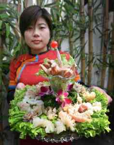 A Chinese waitress displays a dish of ox and dog penis at a restaurant in Beijing 01020115834500 | Bizarro | bizarro, china, comida, curioso, estranho, horrível, nojento, Viagem