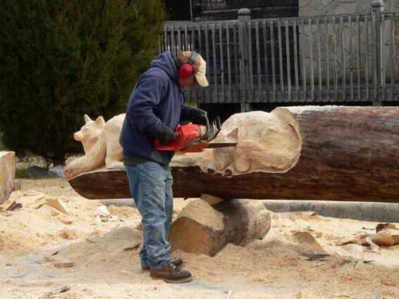 O fera da motoserra Detalhe de escultura animal em madeira com motoserra