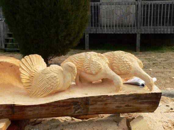 O fera da motoserra Escultura de urso em tronco de árvore feita com motoserra