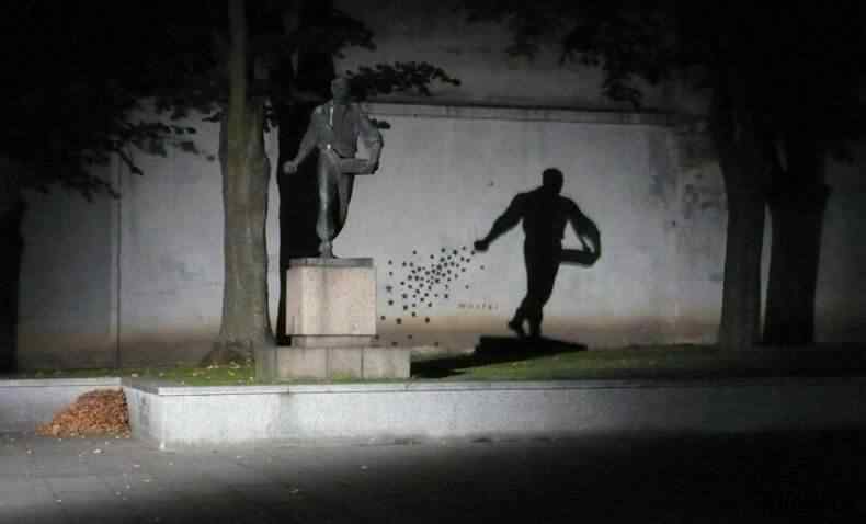 Semeador de estrelas à noite Efeito da sombra da estátua com estrelas pintadas no muro ao anoitecer