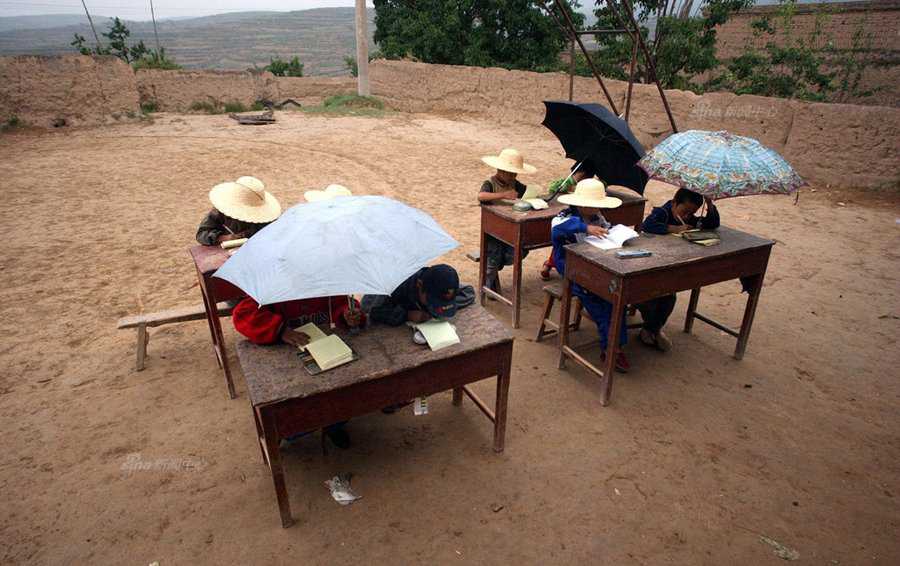 O problema do Brasil não é a Educação Esta foto foi tirada em 29 de Abril de 2004, às Xishan Village, a menos de 10 km de Lanzhou, capital da província de Gansu. Devido à condição estrutura perigosa de sua escola, alguns alunos têm de ter aulas ao ar livre, com um chapéu de palha e guarda-chuva para se proteger contra o sol ea chuva. (Fonte: sina.com.cn)